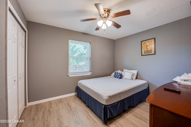 bedroom with hardwood / wood-style flooring, ceiling fan, and a closet