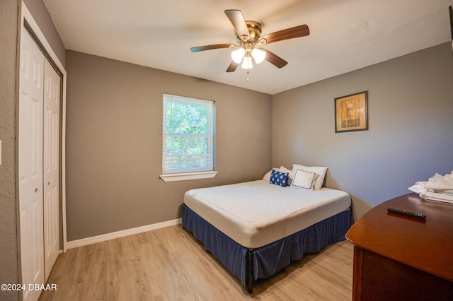 bedroom featuring hardwood / wood-style flooring, ceiling fan, and a closet