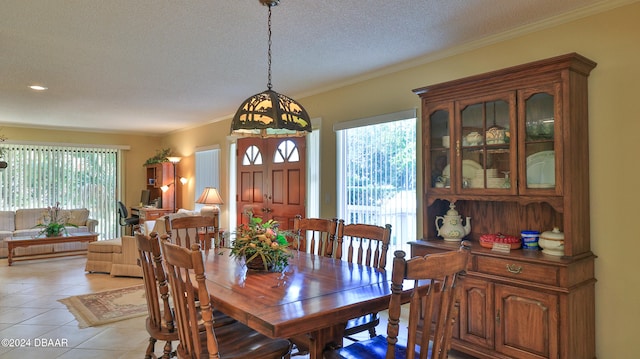 dining area with a textured ceiling, light tile patterned floors, and plenty of natural light