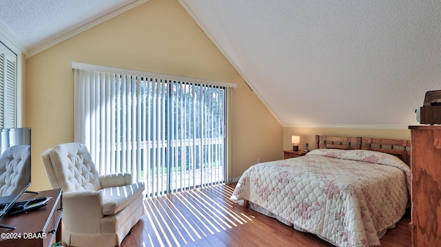 bedroom featuring access to outside, lofted ceiling, hardwood / wood-style flooring, and crown molding