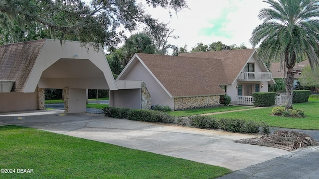 view of front of house with a front lawn and a balcony