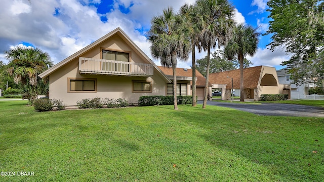 view of front of house featuring a front lawn and a balcony