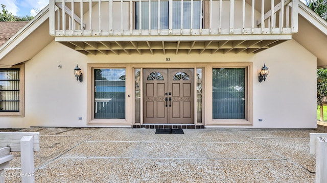 view of exterior entry with a balcony