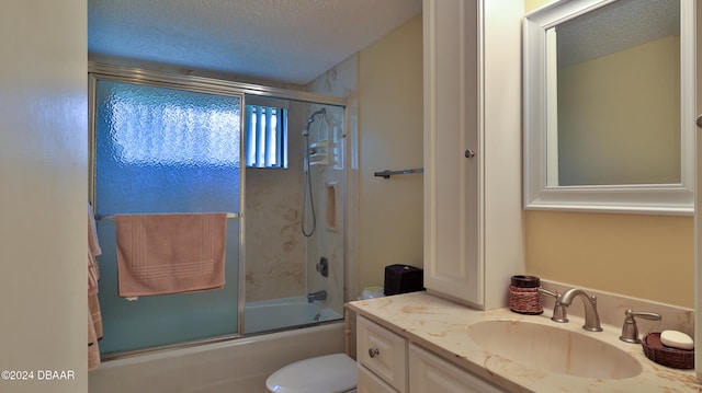 full bathroom with toilet, combined bath / shower with glass door, vanity, and a textured ceiling