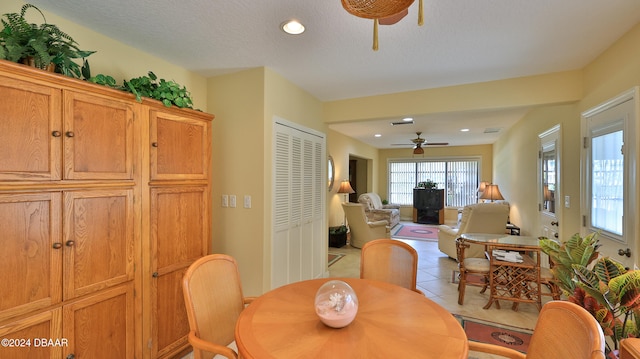 tiled dining space featuring ceiling fan and a textured ceiling