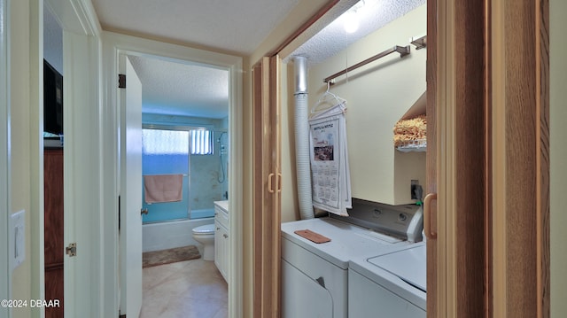 washroom featuring washing machine and dryer and a textured ceiling