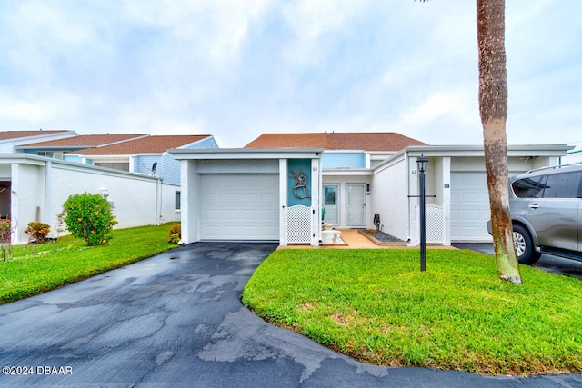 single story home featuring a garage and a front yard