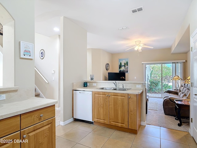 kitchen with kitchen peninsula, sink, light tile patterned floors, ceiling fan, and white dishwasher