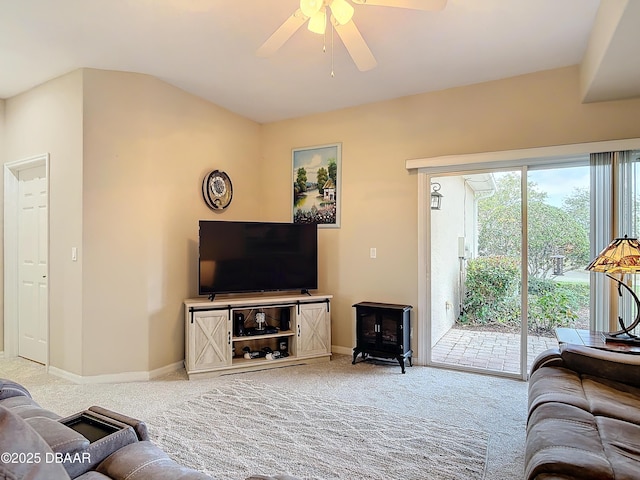 living area featuring carpet flooring, baseboards, and a ceiling fan