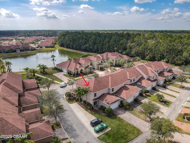 birds eye view of property featuring a wooded view, a residential view, and a water view