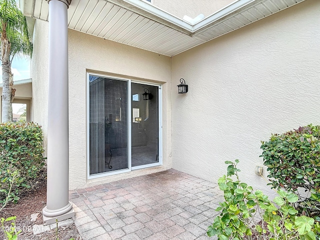 entrance to property with a patio and stucco siding