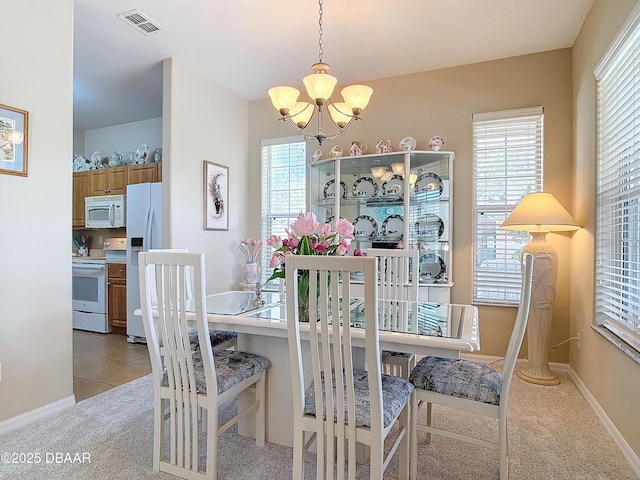 dining room with visible vents, baseboards, a chandelier, light colored carpet, and light tile patterned flooring