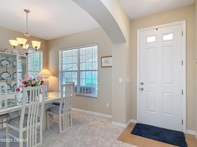 dining room featuring light carpet and a notable chandelier