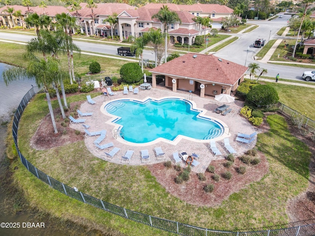 pool featuring a patio area, a residential view, a yard, and fence