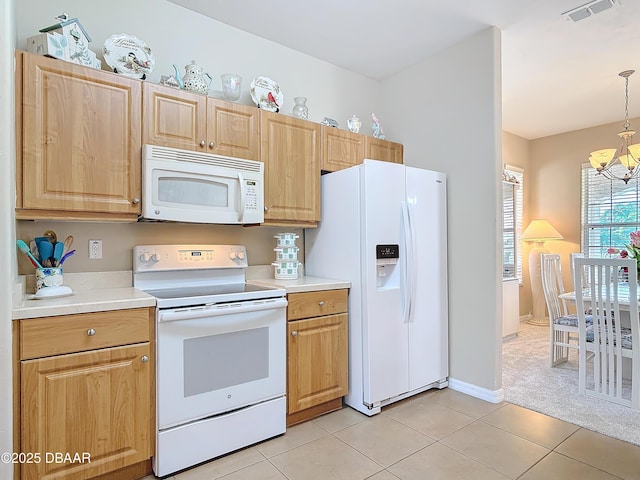 kitchen with a chandelier, pendant lighting, white appliances, and light tile patterned floors