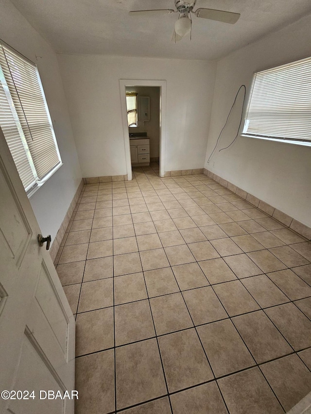 empty room with light tile patterned flooring and ceiling fan