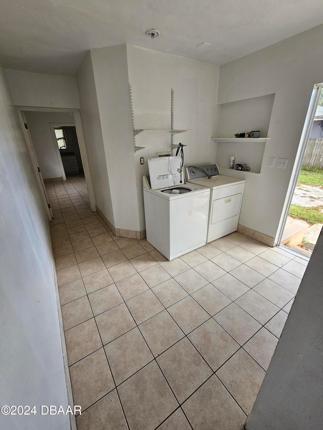 clothes washing area with built in features, light tile patterned floors, and independent washer and dryer