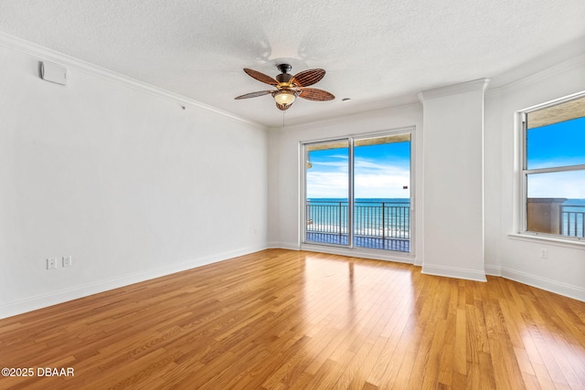 2515 S Atlantic Ave Unit 507, Daytona Beach Shores, FL 32118 - empty room featuring light wood finished floors, a ceiling fan, a textured ceiling, ornamental molding, and a water view