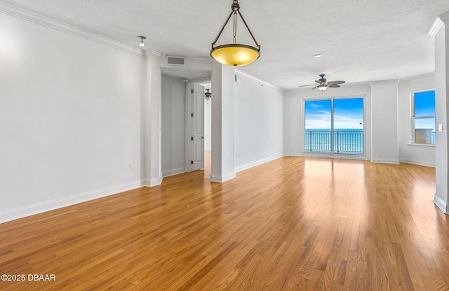 2515 S Atlantic Ave Unit 507, Daytona Beach Shores, FL 32118 - empty room featuring a textured ceiling, ornamental molding, plenty of natural light, light wood-type flooring, and ceiling fan