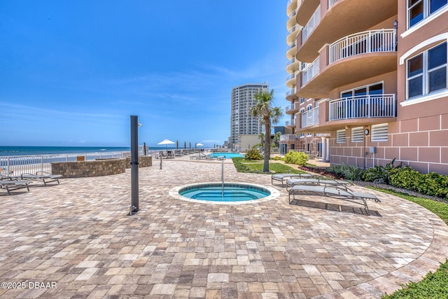 2515 S Atlantic Ave Unit 507, Daytona Beach Shores, FL 32118 - view of swimming pool with a community hot tub, a water view, and a patio