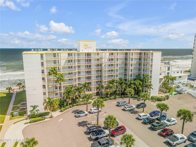 view of building exterior featuring a water view and a view of the beach