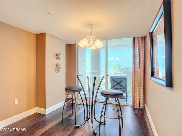 dining area with dark wood-type flooring, a wealth of natural light, and an inviting chandelier