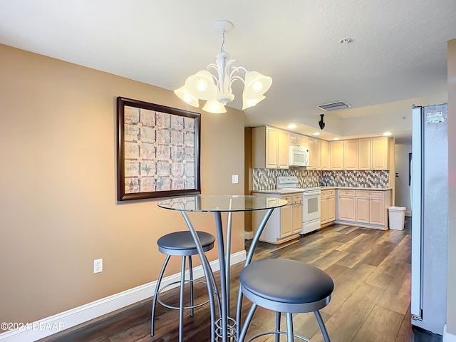 kitchen featuring a chandelier, backsplash, decorative light fixtures, dark hardwood / wood-style flooring, and white appliances