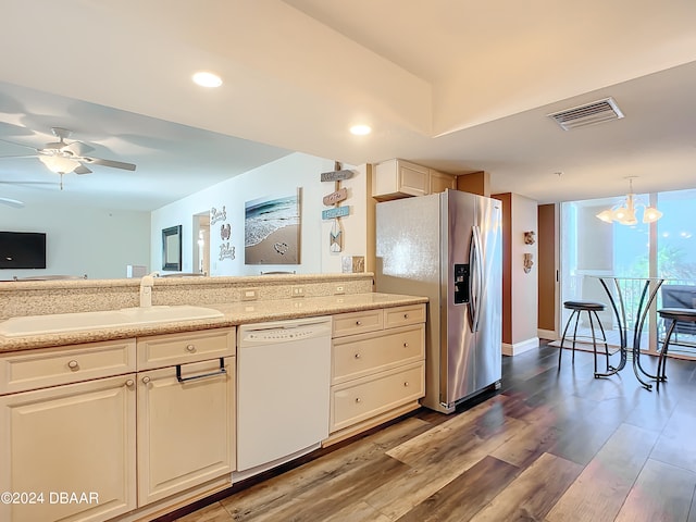 kitchen featuring stainless steel fridge, pendant lighting, hardwood / wood-style floors, dishwasher, and ceiling fan with notable chandelier