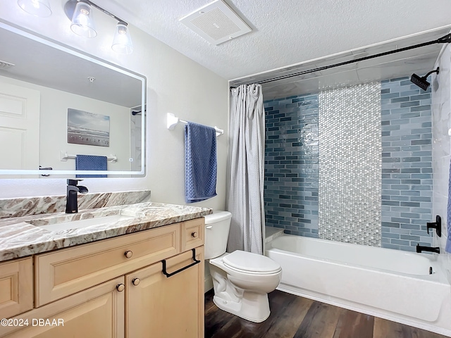 full bathroom with toilet, hardwood / wood-style floors, a textured ceiling, vanity, and shower / bathtub combination with curtain