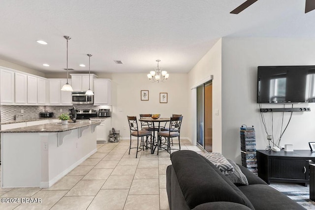 161 Tarracina Way, Daytona Beach, FL 32117 - kitchen featuring appliances with stainless steel finishes, dark stone countertops, light tile patterned floors, decorative backsplash, and white cabinets
