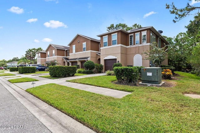 161 Tarracina Way, Daytona Beach, FL 32117 - townhome / multi-family property with a garage, stucco siding, a front lawn, driveway, and a residential view