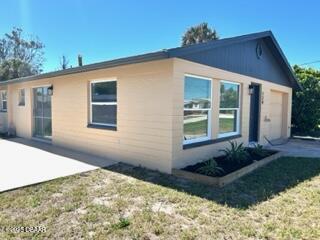 124 Harrison Rd, Daytona Beach, FL 32118 - view of side of home with a patio and a garage