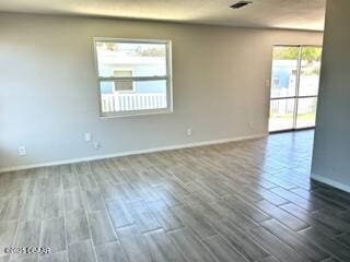 124 Harrison Rd, Daytona Beach, FL 32118 - unfurnished room featuring baseboards and dark wood-style floors