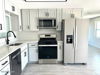 124 Harrison Rd, Daytona Beach, FL 32118 - kitchen featuring a sink, light countertops, stainless steel appliances, and light wood-type flooring
