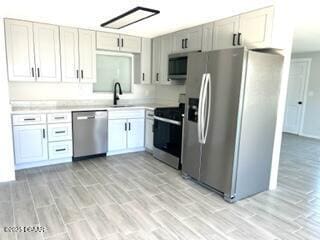 124 Harrison Rd, Daytona Beach, FL 32118 - kitchen featuring light countertops, a sink, appliances with stainless steel finishes, and wood finish floors