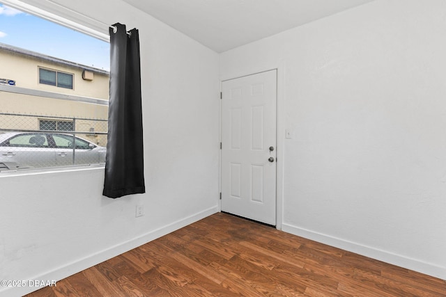 unfurnished room with baseboards and wood finished floors