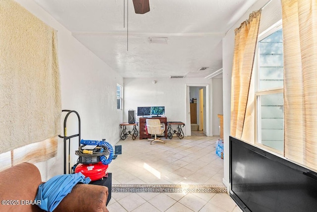 interior space featuring a ceiling fan, visible vents, and tile patterned floors