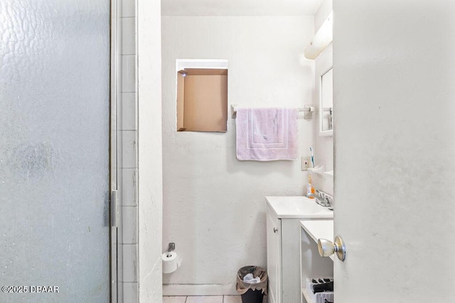 bathroom with a shower with shower door, tile patterned flooring, and vanity