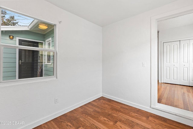 empty room with baseboards and wood finished floors