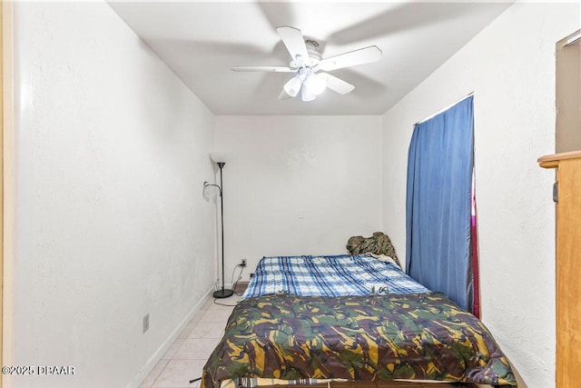 bedroom featuring light tile patterned floors, a ceiling fan, and baseboards