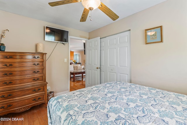 bedroom with ceiling fan, wood-type flooring, and a closet