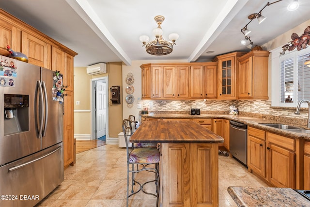 kitchen with a center island, sink, stainless steel appliances, beamed ceiling, and an AC wall unit