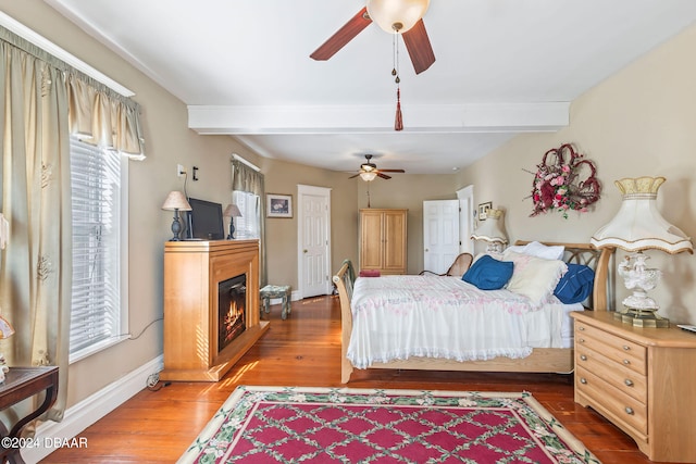 bedroom featuring wood-type flooring, ceiling fan, and beam ceiling