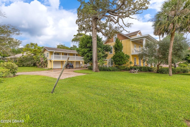 view of front of home featuring a balcony, a front lawn, and a garage