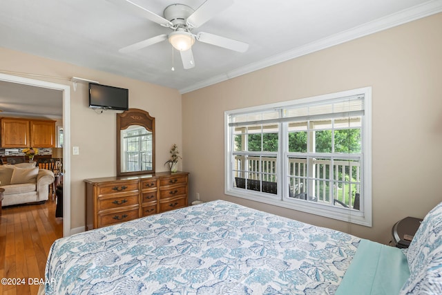 bedroom with hardwood / wood-style flooring, ceiling fan, and crown molding