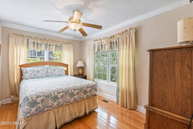 bedroom with multiple windows, crown molding, ceiling fan, and light hardwood / wood-style floors