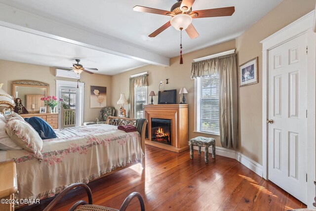 bedroom with ceiling fan, dark hardwood / wood-style flooring, and multiple windows