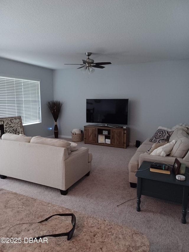 carpeted living room with a textured ceiling and ceiling fan