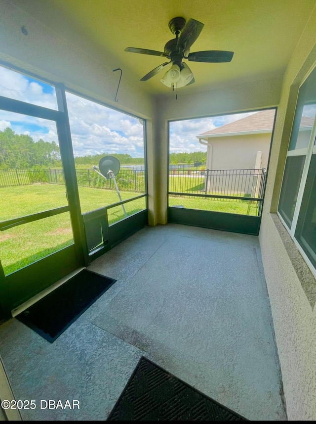 unfurnished sunroom with ceiling fan