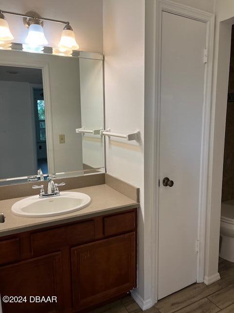 bathroom featuring hardwood / wood-style floors, vanity, and toilet